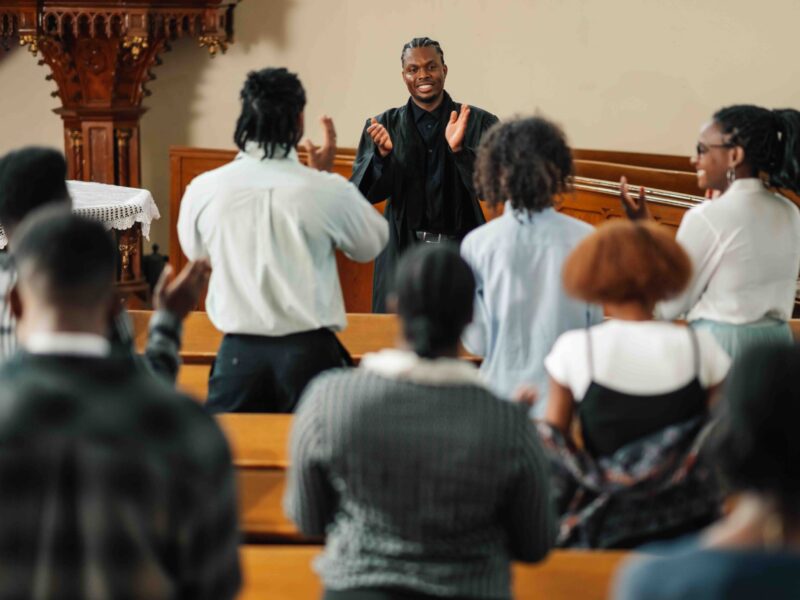 Diverse congregation gathers in a vibrant church as a passionate pastor delivers an inspiring sermon, drawing them closer in prayer and praise